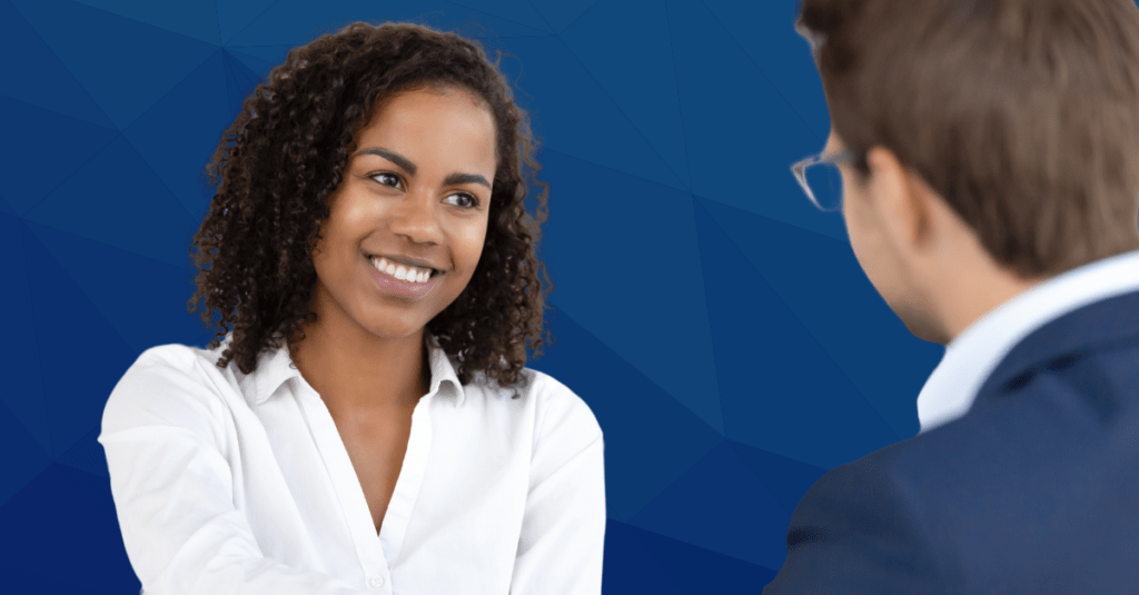 curly haired woman interview candidate shakes hand after successful interview